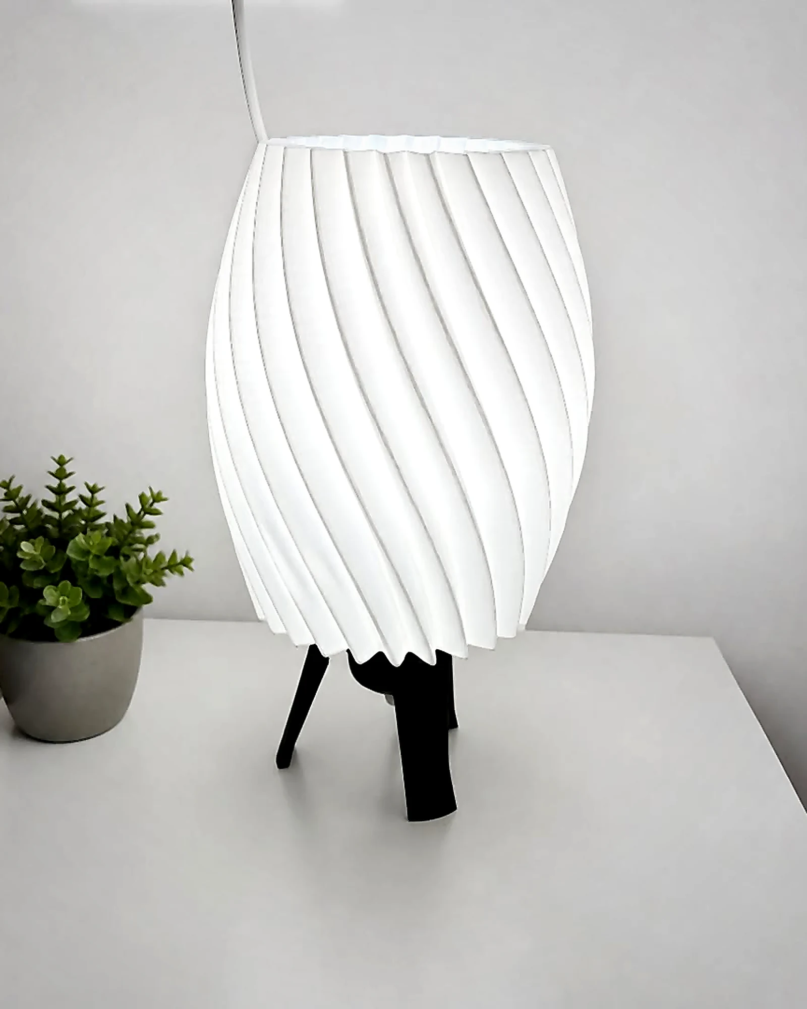 Bela spiralna 3D lampa na crnim nogicama